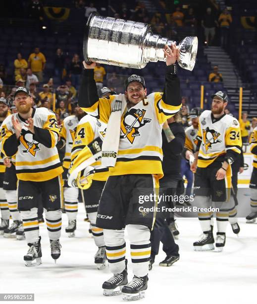 Sidney Crosby of the Pittsburgh Penguins and his teammates celebrate with the Stanley Cup trophy after defeating the Nashville Predators 2-0 in Game...