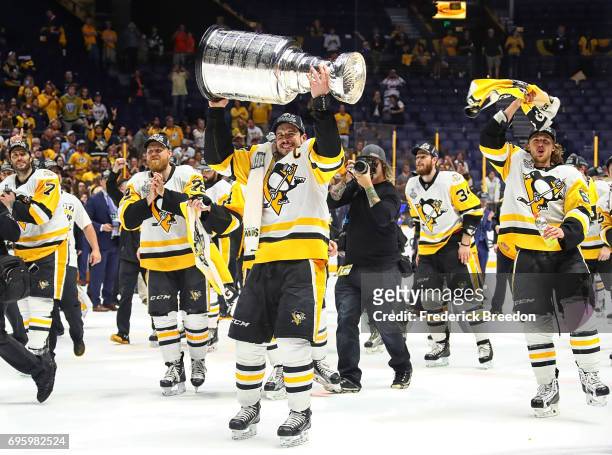 Sidney Crosby of the Pittsburgh Penguins and his teammates celebrate with the Stanley Cup trophy after defeating the Nashville Predators 2-0 in Game...