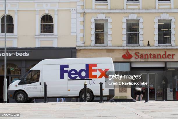 fedex delivery van travelling through the centre of cirencester in the cotswolds. - corporate car fleet stock pictures, royalty-free photos & images
