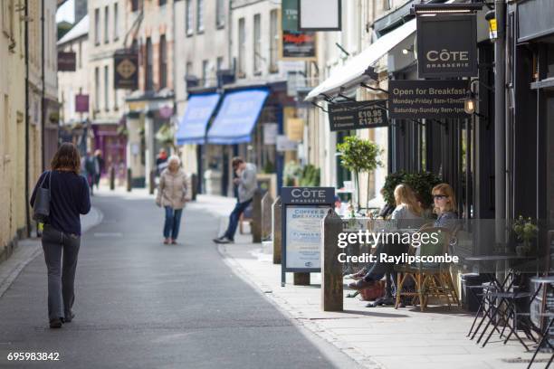 visitors taking a welcome refreshment break in the cafes along black jack street in cirencester, england. - cirencester stock pictures, royalty-free photos & images