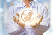 In the doctor's hands, the icon of the embryo.