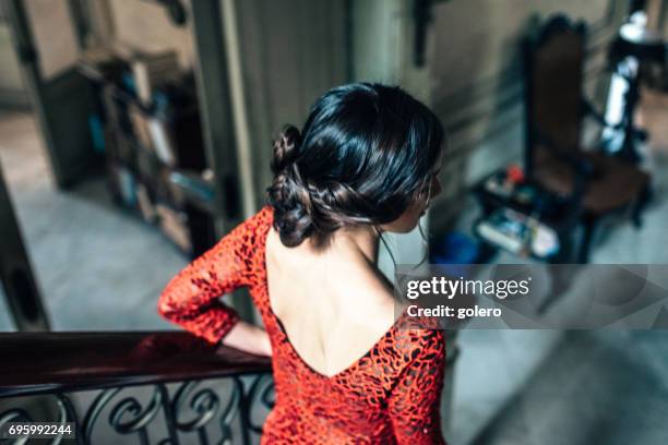 jeune femme cubaine en robe rouge en descendant les escaliers dans vieille maison - femme décolleté photos et images de collection