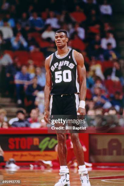 David Robinson of the San Antonio Spurs stands on the court against the Houston Rockets during a game played circa 1990 at the Summit in Houston,...