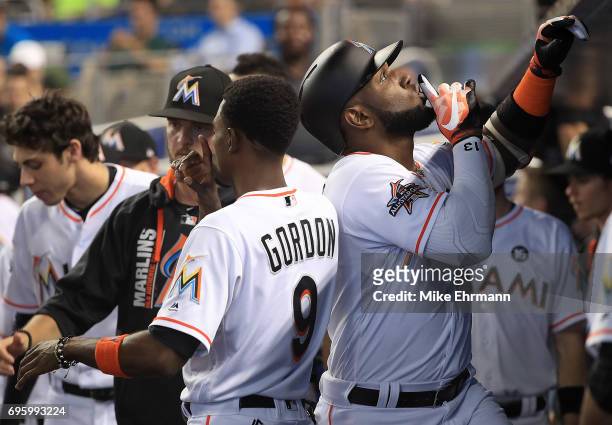 Marcell Ozuna of the Miami Marlins is congratulated by Dee Gordon after hitting a solo home run during a game against the Oakland Athletics at...