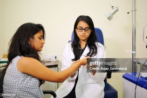 doctor checking pulse - india doctor foto e immagini stock
