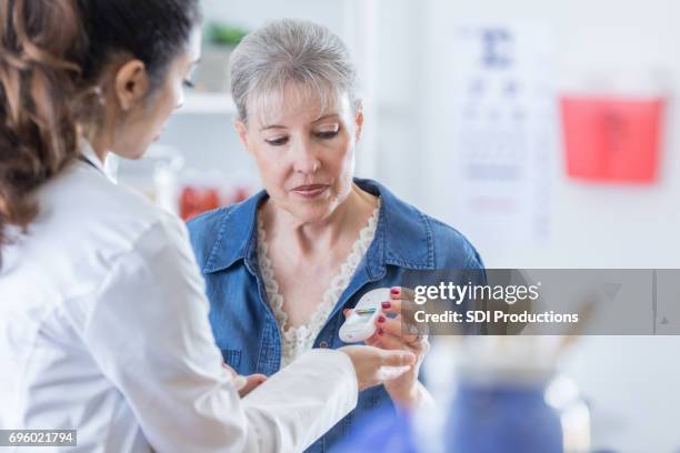 dokter leert de patiënt te gebruiken van een glaucometer - glaucometer stockfoto's en -beelden