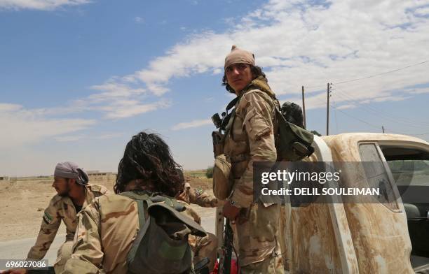 Opposition members of Ahmad Jarba's Syrian Elite Forces, fighting alongside the Syrian Democratic Forces , ride a truck in a neighbourhood on the...