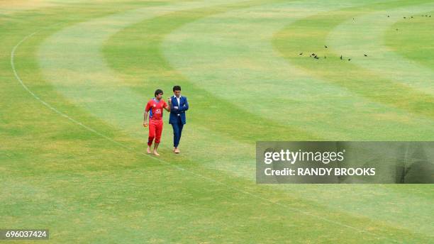 Captain Asghar Stanikzai and manager Shir Agha Hamkar of Afghanistan walk around the field as rain delays the start of the 3rd and final ODI match...