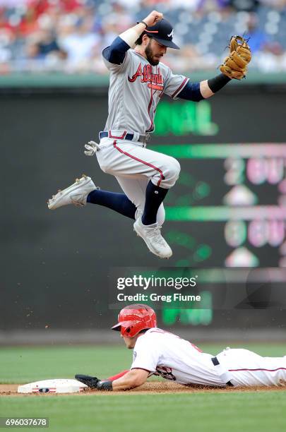 Dansby Swanson of the Atlanta Braves jumps over Trea Turner of the Washington Nationals in the first inning at Nationals Park on June 14, 2017 in...