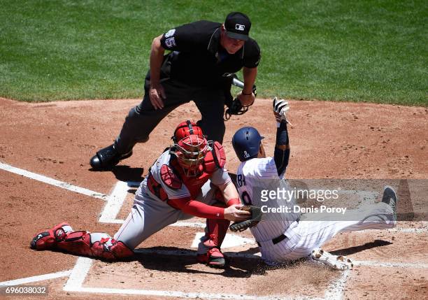 Erick Aybar of the San Diego Padres misses the plate as Tucker Barnhart of the Cincinnati Reds tries to tag him during the second inning of a...