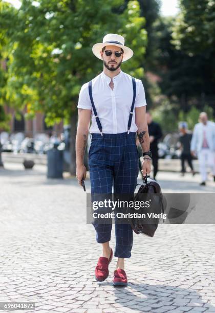 Kadu Dantas wearing white button shirt with short sleeves, suspenders, checked pants is seen during Pitti Immagine Uomo 92. At Fortezza Da Basso on...