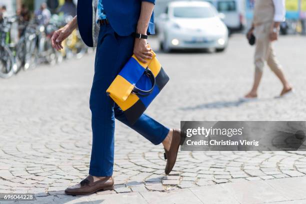 Guest wearing a clutch is seen during Pitti Immagine Uomo 92. At Fortezza Da Basso on June 14, 2017 in Florence, Italy.