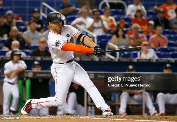 The Miami Marlins' Giancarlo Stanton hits a single during the third inning against the Oakland Athletics at Marlins Park on Wednesday, June 14 in...