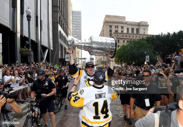 Evgeni Malkin of the Pittsburgh Penguins hands the Stanley Cup to Chris Kunitz during the Pittsburgh Penguins Victory Parade And Rally on June 14,...