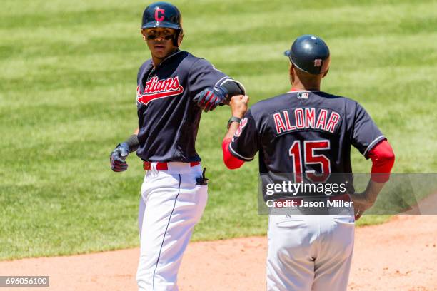 Erik Gonzalez of the Cleveland Indians celebrates with first base coach Sandy Alomar Jr. #15 after Gonzalez reaches first on a single during the...