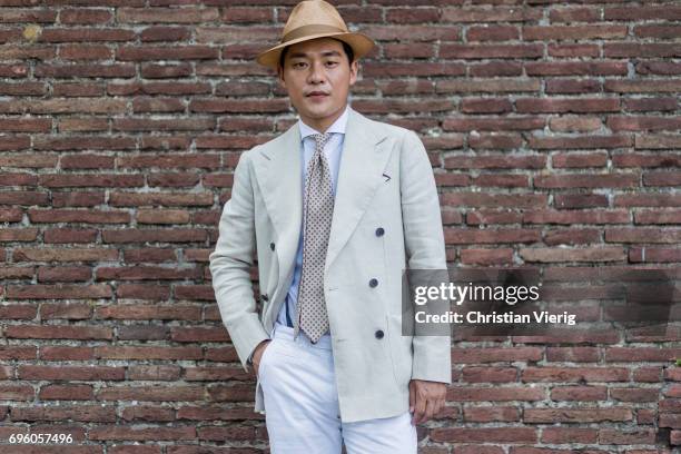 Seongsu Kim wearing a hat, creme blazer jacket, white pants is seen during Pitti Immagine Uomo 92. At Fortezza Da Basso on June 14, 2017 in Florence,...