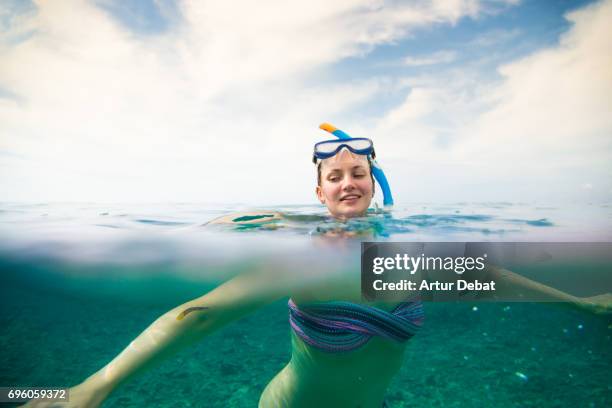 traveler girl doing snorkel in the gili islands a paradise in the indonesia during travel vacations in the islands. - half underwater foto e immagini stock