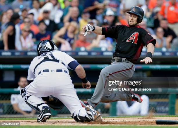 Chris Owings of the Arizona Diamondbacks slides into the tag from catcher Alex Avila of the Detroit Tigers during the first inning at Comerica Park...