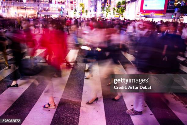 long exposure picture of people crossing in the scramble crossing of shibuya at night with nice motion effect. - zebra crossing abstract stock pictures, royalty-free photos & images