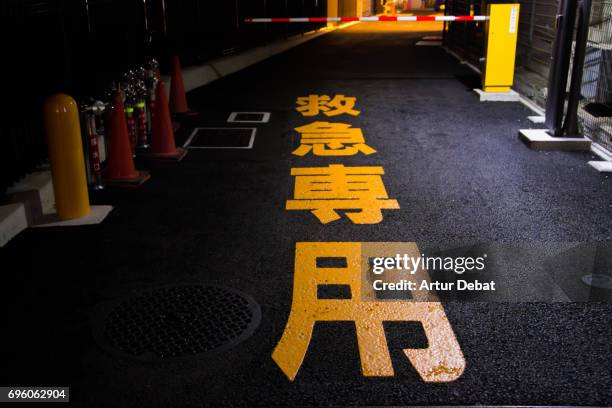 beautiful orange japanese letter in the asphalt of the tokyo city streets at night. - black alley stock pictures, royalty-free photos & images