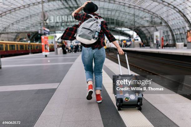 backpacker getting rushingto catch a train - luggage trolley stock-fotos und bilder