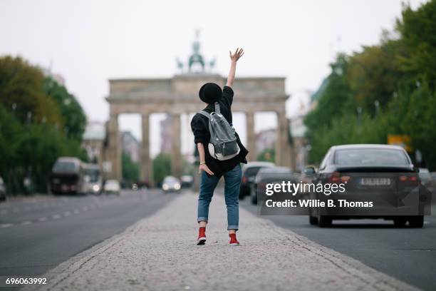 a woman waving to brandenburg gate - brandenburg gate berlin stock pictures, royalty-free photos & images