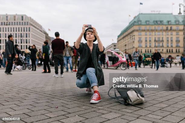 a tourist kneeling down taking photo - photographing bildbanksfoton och bilder