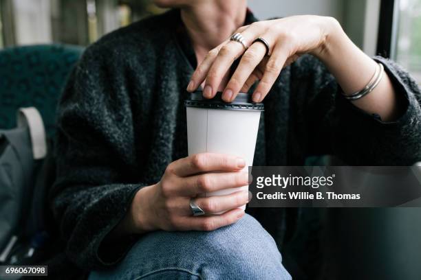 a woman holding a takeout coffee - coffee drink photos et images de collection