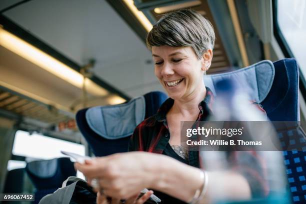 woman looking over map on train - passenger train fotografías e imágenes de stock