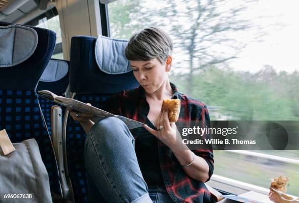 woman on train eating snack - bahnreisender stock-fotos und bilder