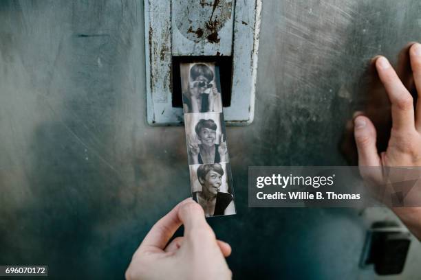 photo strip being printed out from booth - photo booth stock pictures, royalty-free photos & images