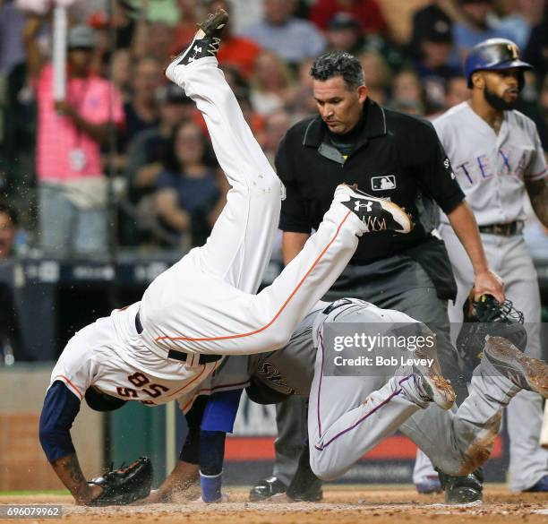 Jonathan Lucroy of the Texas Rangers scores on a wild pitch in the fifth inning asFrancis Martes of the Houston Astros tumbles over him at Minute...