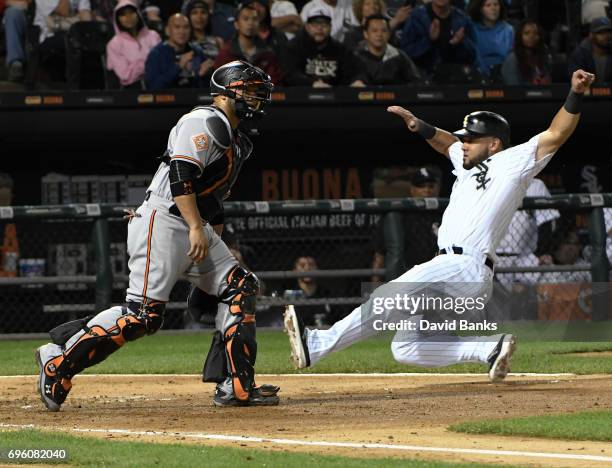 Melky Cabrera of the Chicago White Sox slides safely into home plate as Welington Castillo of the Baltimore Orioles waits for the throw during the...