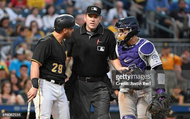 Francisco Cervelli of the Pittsburgh Pirates has words with Tony Wolters of the Colorado Rockies after being hit by a pitch in the fifth inning...