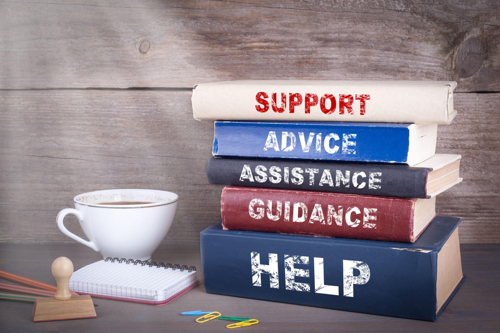 Support concept. Stack of books on wooden desk Support concept. Stack of books on wooden desk