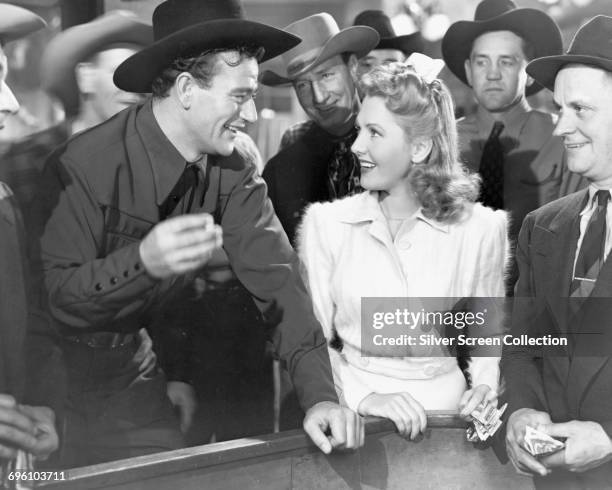 Actors Jean Arthur as Molly J. Truesdale and John Wayne as Duke Hudkins in the romantic comedy 'A Lady Takes a Chance', 1943.