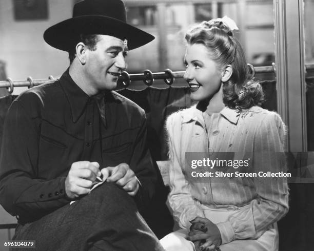 Actors Jean Arthur as Molly J. Truesdale and John Wayne as Duke Hudkins in the romantic comedy 'A Lady Takes a Chance', 1943.