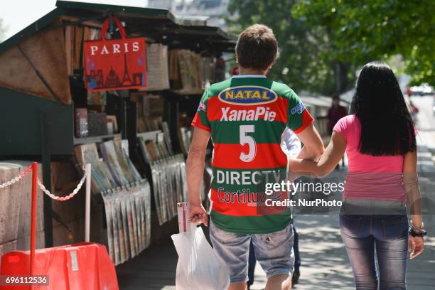 Couple of tourists passes near stands selling souvenirs and memorabilia along Seine river, near Notre Dame Cathedral in Paris, as visitor numbers...