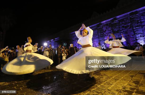 Syrian whirling dervishes perform in a celebration during the Muslim holy month of Ramadan outside the Umayyad Mosque in the old city of the capital...