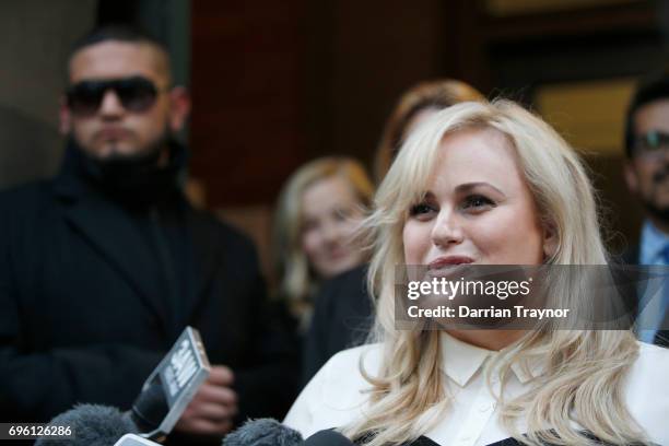 Rebel Wilson speaks to the media as her security personnel looks on on June 15, 2017 in Melbourne, Australia. After a three week trial, a jury of six...