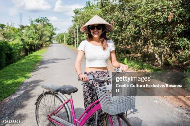 woman wearing traditional rice hat beside bicycle, tan phong island, vietnam - cultura orientale photos et images de collection
