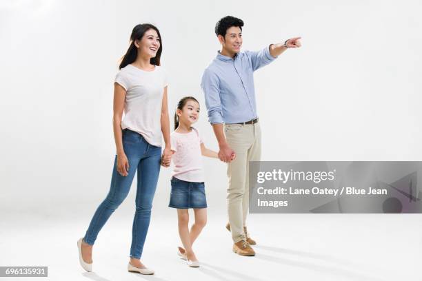 cheerful young family - couple pointing imagens e fotografias de stock