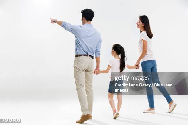 cheerful young family - couple pointing imagens e fotografias de stock