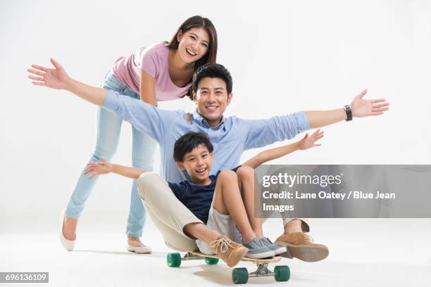 young family playing with skateboard - monopatín artículos deportivos fotografías e imágenes de stock