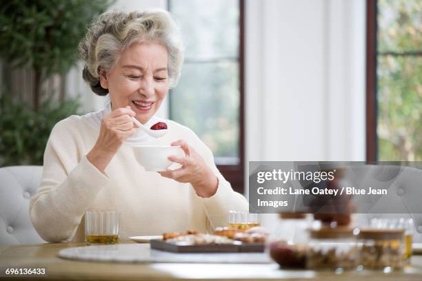 happy senior woman having breakfast - chinese soup bildbanksfoton och bilder