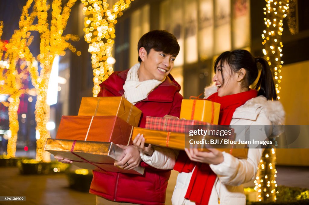 Happy young couple with new year gifts