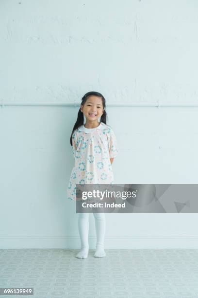 girl smiling, standing by wall - japanese girl fotografías e imágenes de stock