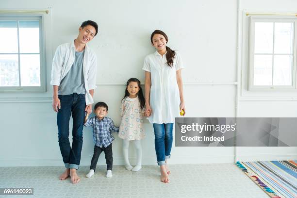 girl placing pear on her head, parents are behind - family full length stock pictures, royalty-free photos & images