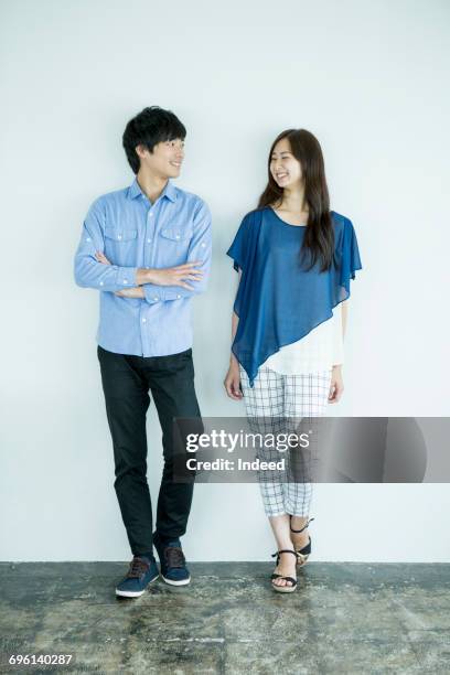 young man and woman standing, smiling face to face - couple standing full length stock pictures, royalty-free photos & images