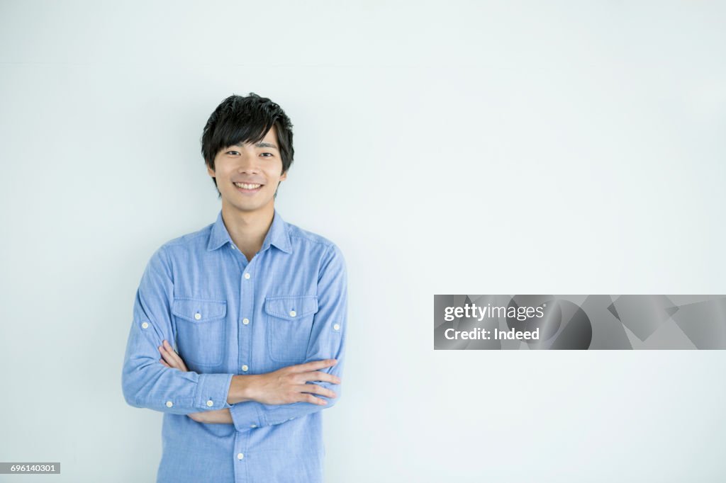 Smiling young man with arms crossed